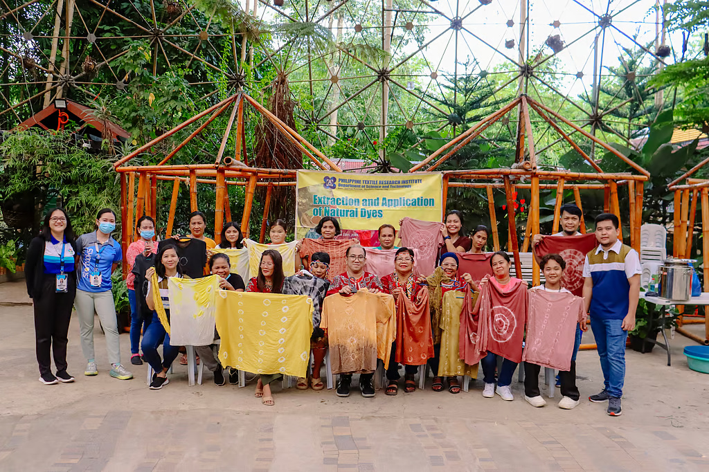 Some Bagobo Tagabawa participants holding their newly dyed clothes, and looking at the camera